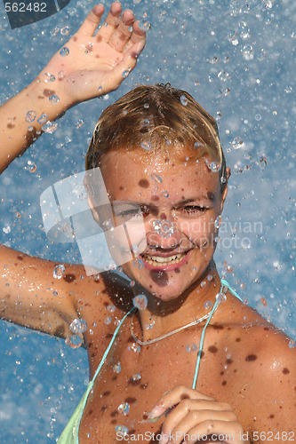 Image of Young beautiful happy smiling tanned blond woman in bikini at rain or summer shower on sea beach