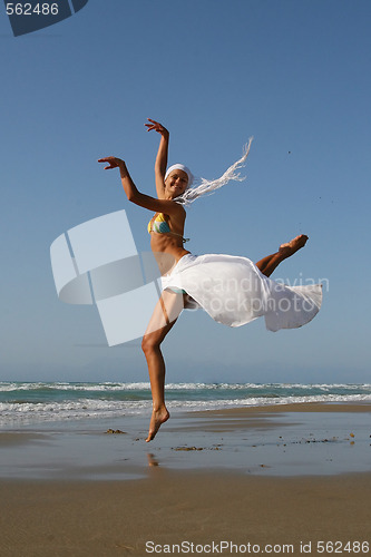 Image of Beautiful young woman jumping on a beach in Greece