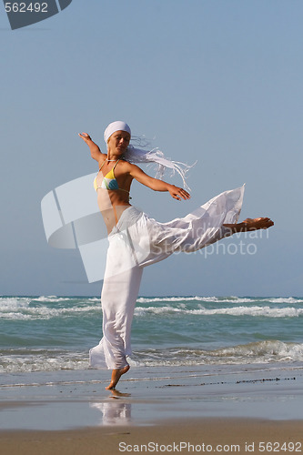 Image of Beautiful young woman jumping on a beach in Greece