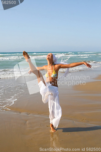 Image of Beautiful girl meditating on the beach