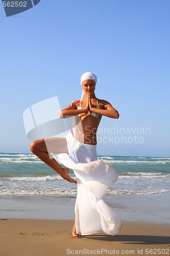 Image of Beautiful girl meditating on the beach