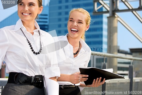 Image of two happy businesswomen with folders