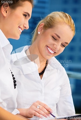 Image of two happy businesswomen with papers
