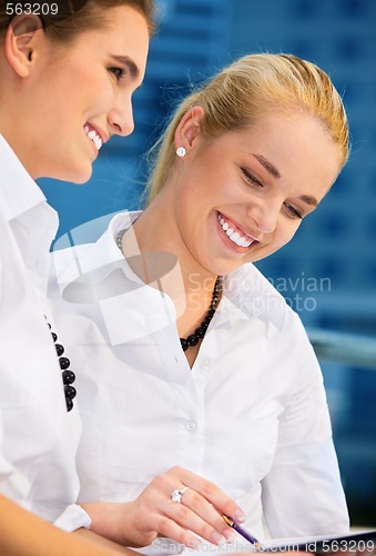 Image of two happy businesswomen with papers