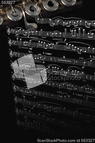 Image of Silver flute instrument resting on a music score