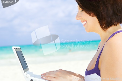 Image of woman with laptop computer on the beach