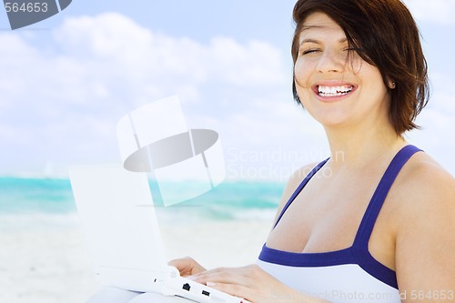 Image of woman with laptop computer on the beach