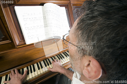 Image of senior middle age man playing piano