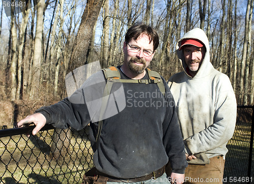 Image of two workmen repairing chain link fence