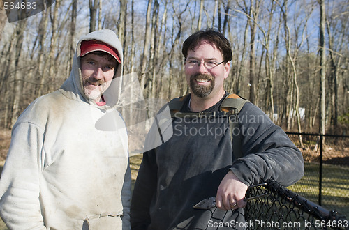 Image of two workmen repairing chain link fence 