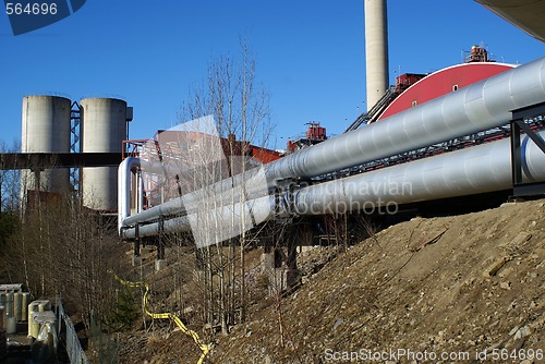 Image of industrial pipelines on pipe-bridge against blue sky