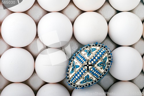 Image of handmade romanian decorated easter egg on white eggs cardboard