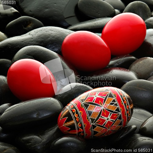 Image of handmade romanian decorated easter egg on black gravel bed