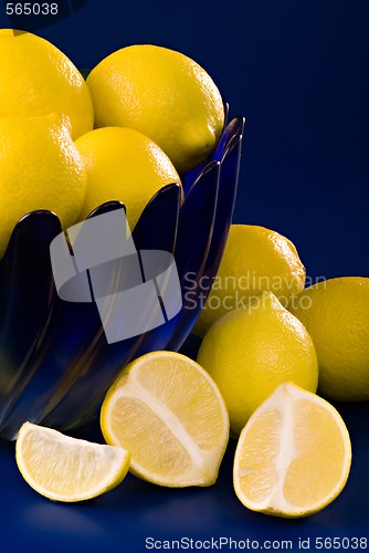 Image of lemons in blue bowl on blue background