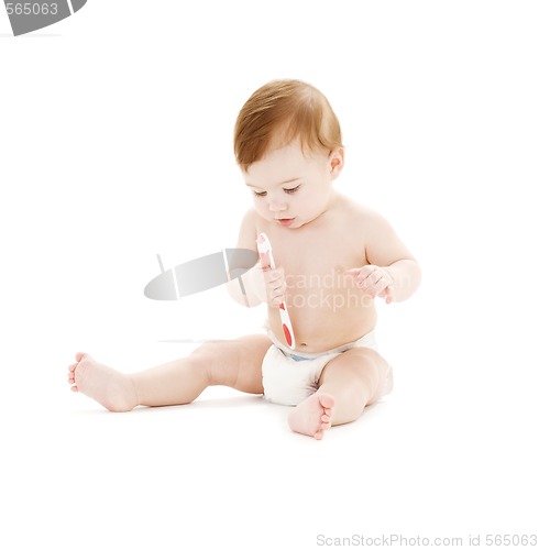Image of baby boy in diaper with toothbrush
