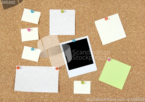 Image of Post-it notes, papers and photo on a corkboard