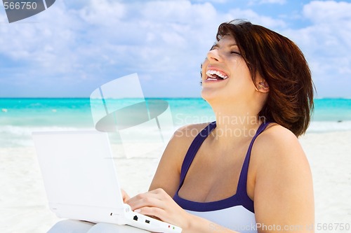 Image of woman with laptop computer on the beach