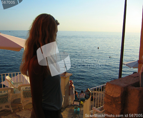 Image of blond women starring at the ocean