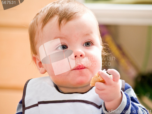 Image of Cute little baby boy eating bread