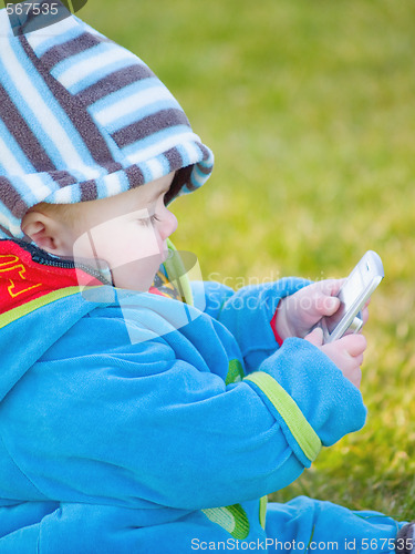 Image of Colourful baby boy playing with cell phone