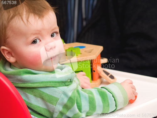 Image of Portrait of a baby boy looking up from playing