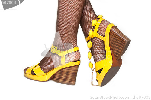 Image of Feminine legs, yellow sandals, accessor