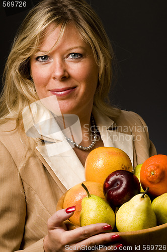 Image of pretty older woman in suit fruit bowl