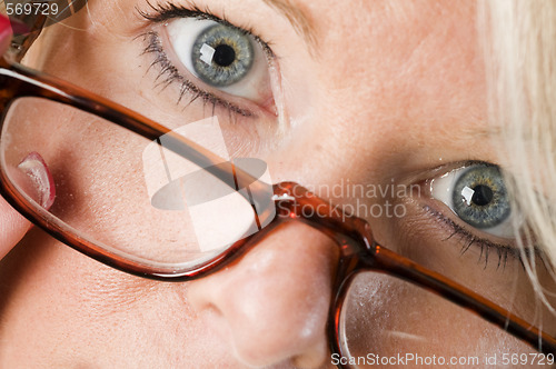 Image of pretty attractive blond woman close up reading glasses