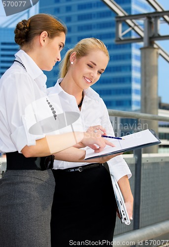 Image of two happy businesswomen with paper chart