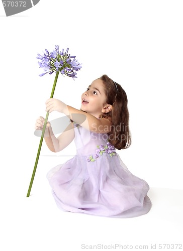 Image of Little girl spinning a large stemmed flower with delight