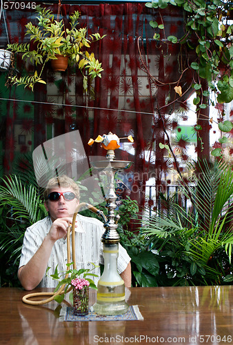 Image of Man smoking a hookah.