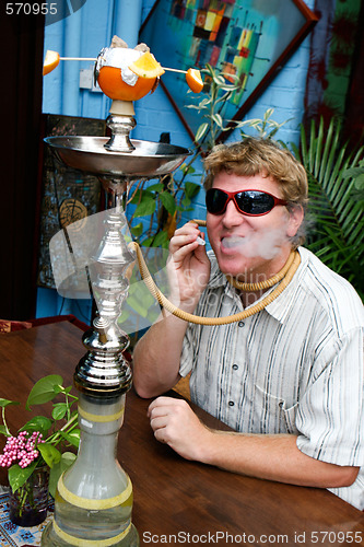 Image of Man smoking a hookah.