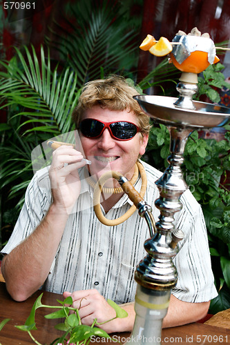 Image of Man smoking a hookah.