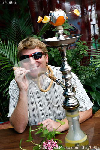 Image of Man smoking a hookah.