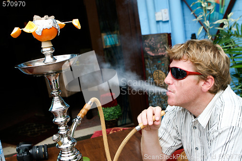 Image of Man smoking a hookah.