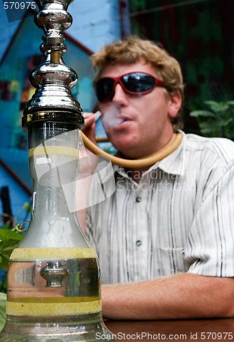 Image of Man smoking a hookah.
