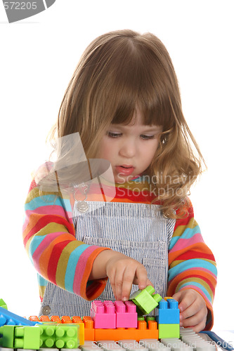 Image of girl playing colorful building toy blocks 