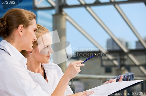 Image of two happy businesswomen with paper chart