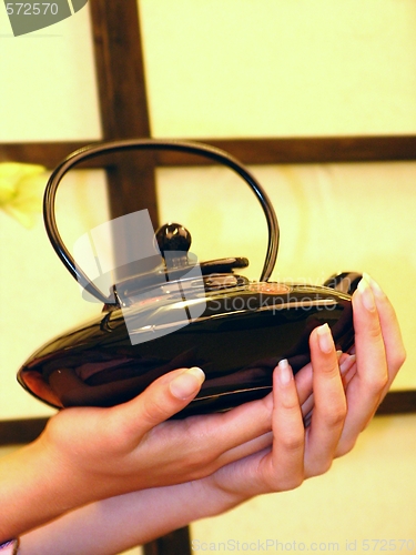 Image of Female hands and teapot