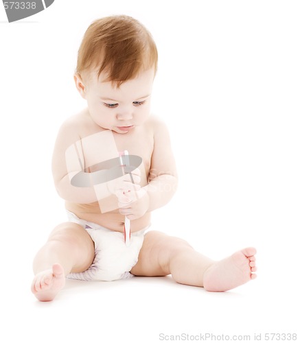 Image of baby boy in diaper with toothbrush