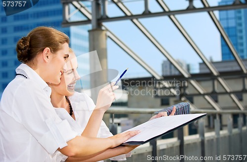 Image of two happy businesswomen with paper chart