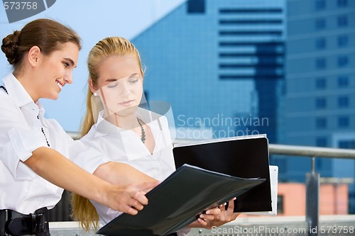 Image of two happy businesswomen with documents