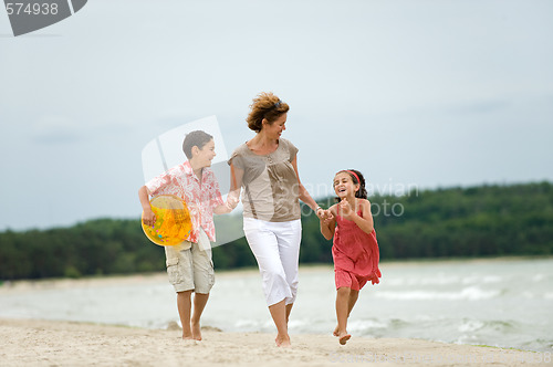 Image of Mother and kids walking on the beach