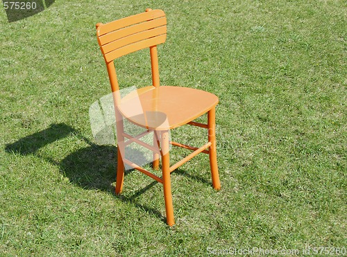 Image of Orange wooden chair on grass