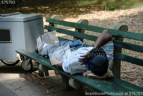 Image of Worker sleeping on park bench