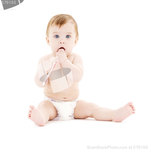 Image of baby boy in diaper with toothbrush