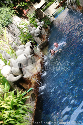 Image of Couple swimming under Thai statues.