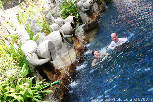 Image of Couple swimming under Thai statues.