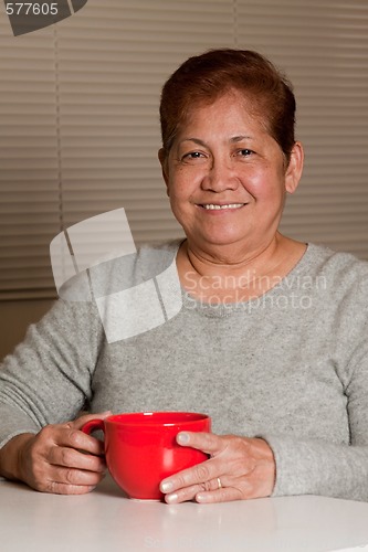 Image of Woman having a cup of coffee at home