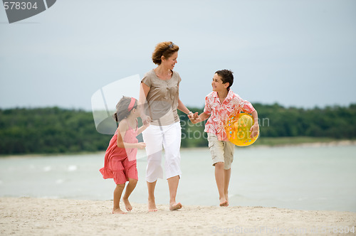 Image of Mother and kids walking on the beach